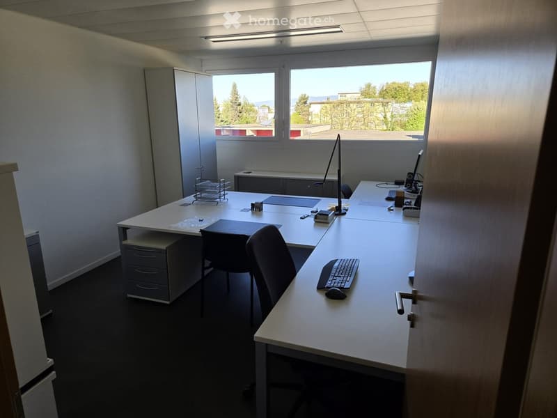 Furnished Room. Office space with a large desk, two chairs, computer setup, and a cabinet.