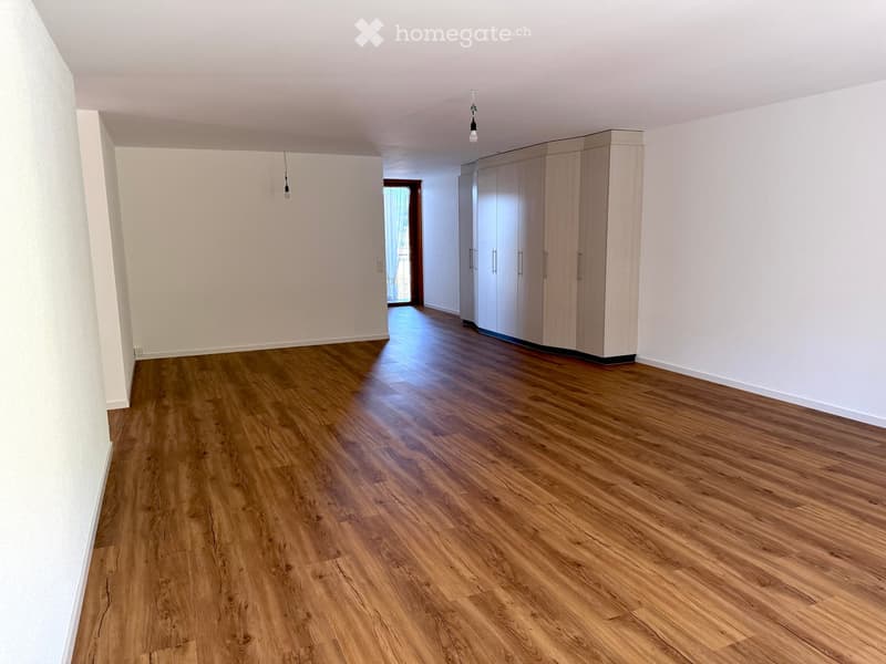 empty room with hardwood floors, white walls, built-in closets, small balcony