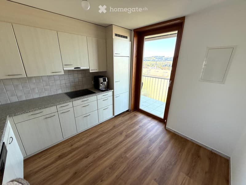 White cabinets, tiled backsplash, granite countertop, black appliances, balcony access, scenic view