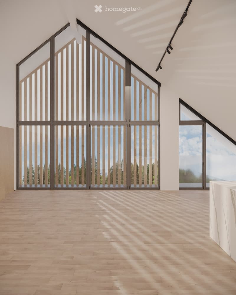 Bright, empty room with large windows and wooden flooring, featuring natural light and a minimalist design.