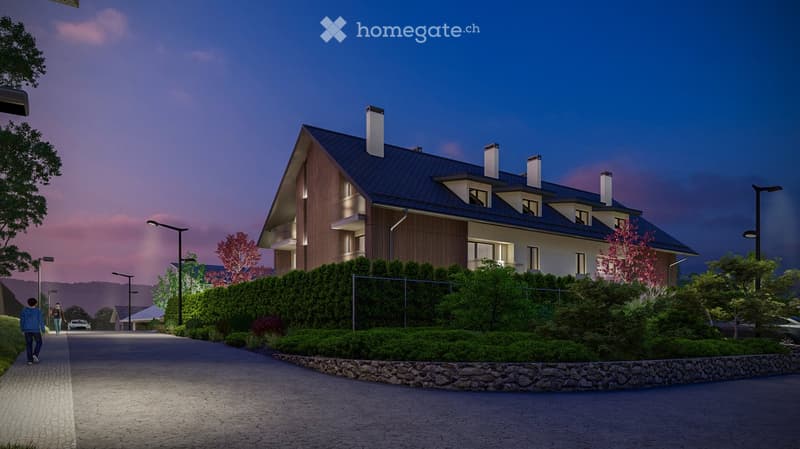 Modern two-story residential building with a dark blue roof, white walls, and multiple chimneys. The building is surrounded by greenery and has a paved driveway leading to it.