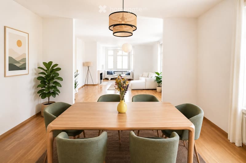 Bright, open-plan living and dining area with wooden flooring, large windows, a dining table with six chairs, a sofa, an ottoman, a floor lamp, and decorative plants.