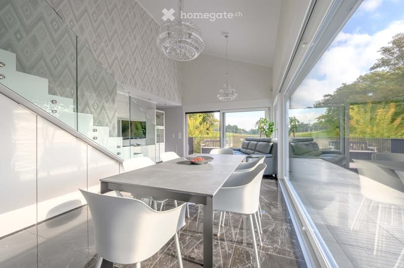 Furnished Room. Modern dining area with a large table, white chairs, and a view of the outdoors.