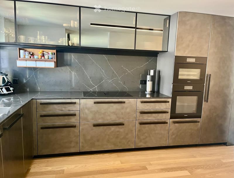 Metal cabinets, black countertops, marble, double oven, stainless steel appliances, wooden floors