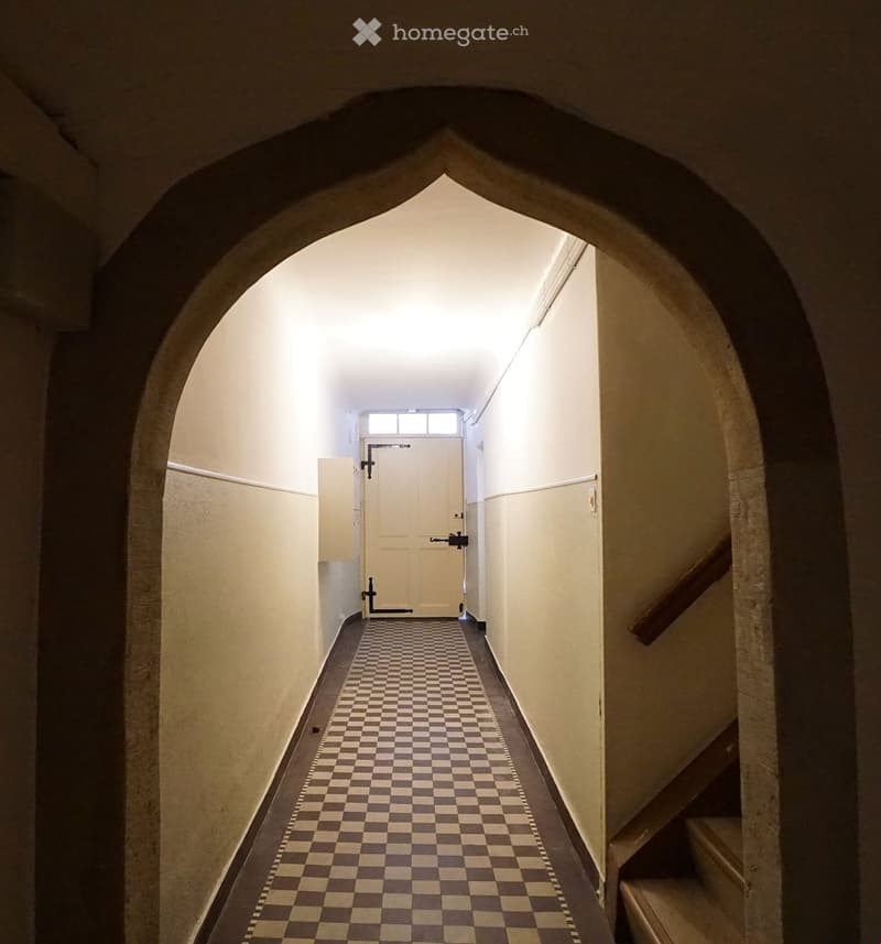 checkered floor, arched entrance, white door, wooden stairs