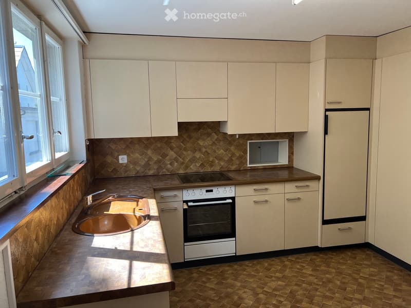 Modern kitchen with light-colored cabinets, a stainless steel oven, a copper sink, and a wooden countertop.