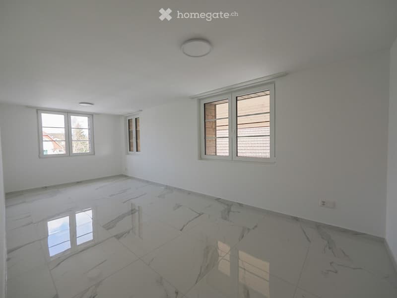 Empty room with white walls, marble flooring, and multiple windows allowing natural light. No furniture or equipment is present.