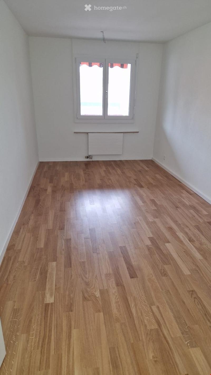 Empty room with wooden flooring, white walls, and a window with white frame. No furniture or equipment present.
