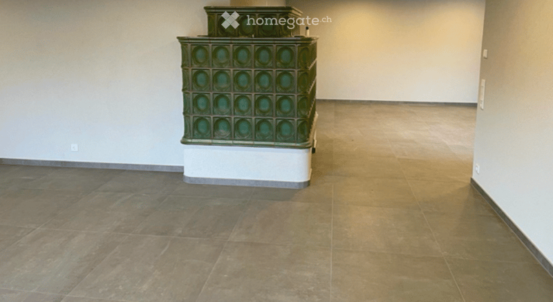 Empty room with tiled floor and a decorative green ceramic structure in the corner.