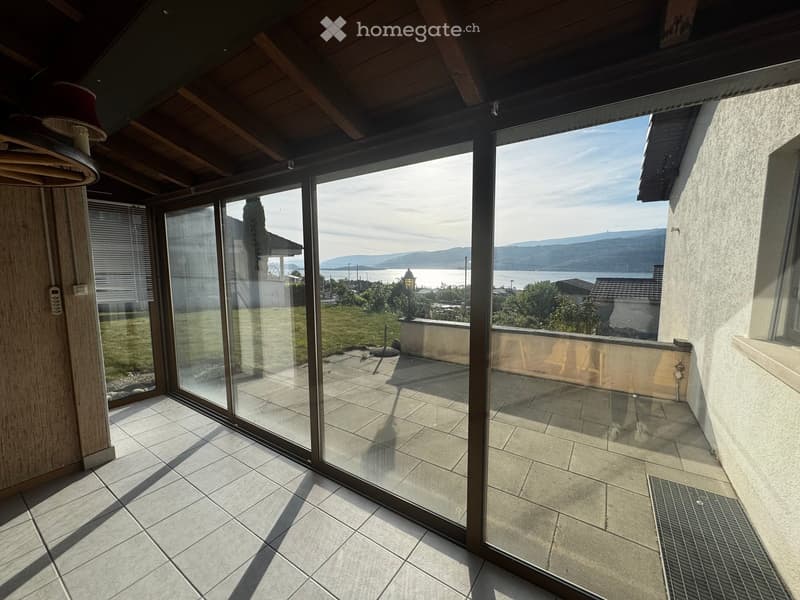 Balcony / Terrace. Balcony with large glass sliding doors, tiled floor, and scenic view of a lake and mountains.