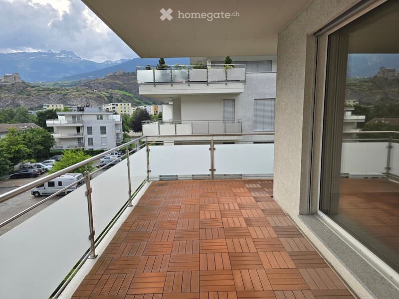 Balcony with wooden decking, metal railing, and scenic mountain view.