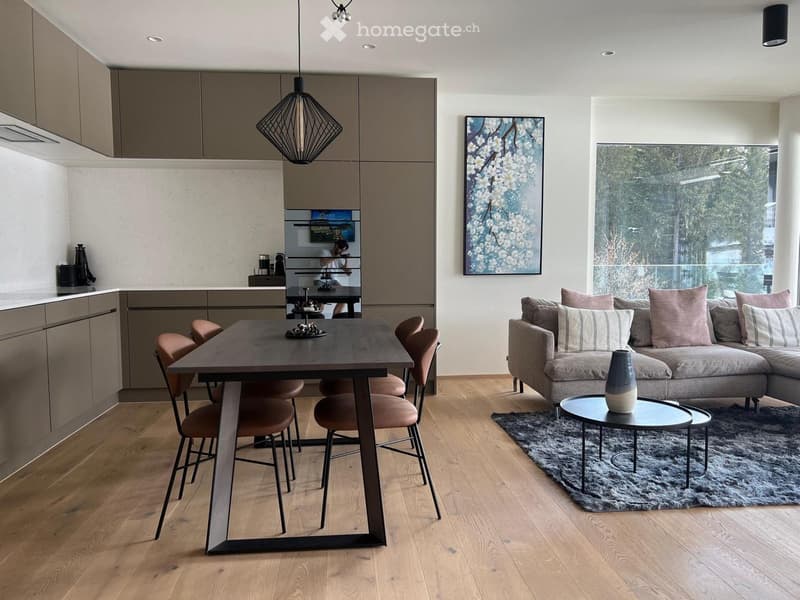 modern kitchen with dining area, large windows, couch, coffee table, rug, artwork