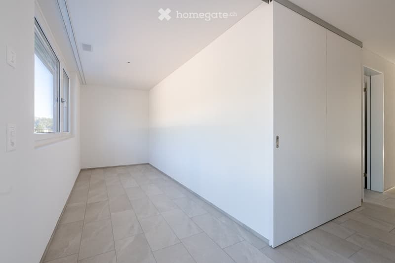 empty room, white walls, gray tile flooring, large window, built-in wardrobe