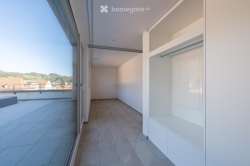 empty room with floor tiles, large glass door, glass window, built-in wardrobe, and large balcony