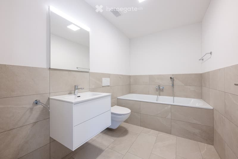 Bathroom with a bathtub, toilet, sink and a mirror