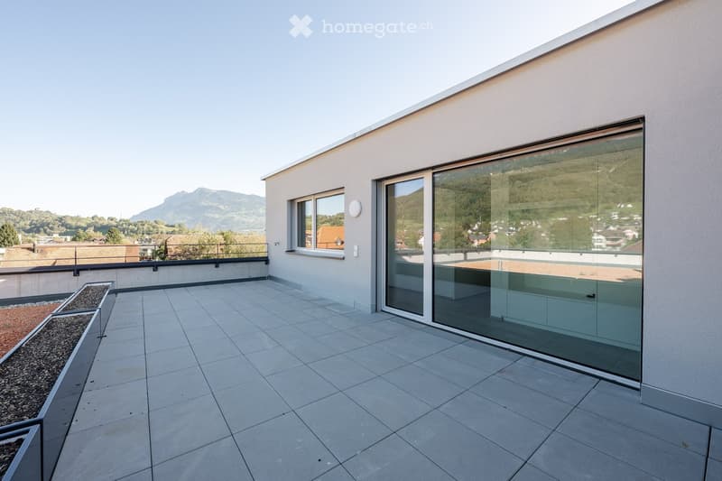 Roof terrace with large windows, tile flooring, railing, and city view