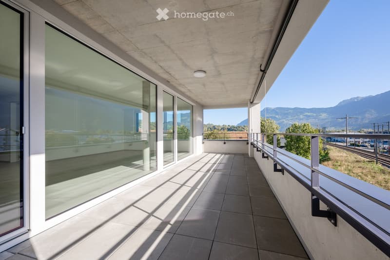 glass walls, tiled floor, metal railings, mountain view