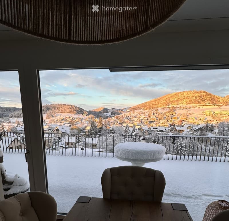 large windows, balcony, snow-covered landscape, mountains, dining table, chairs