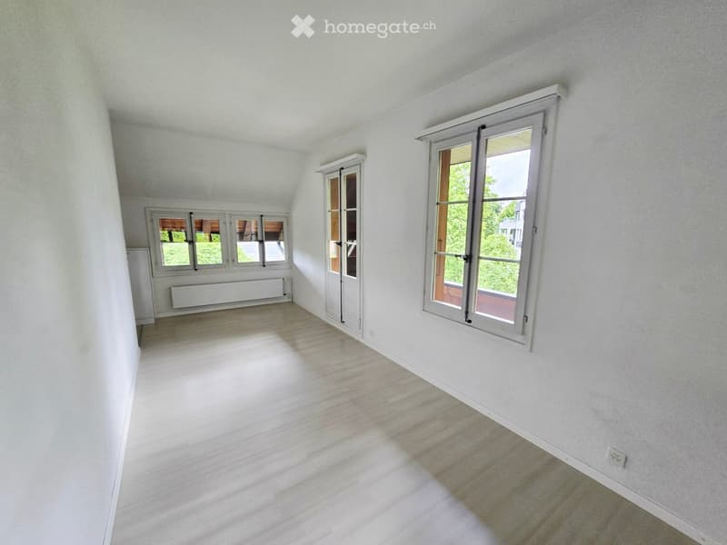 Empty room with white walls, wooden flooring, and multiple windows allowing natural light. No furniture or equipment present.