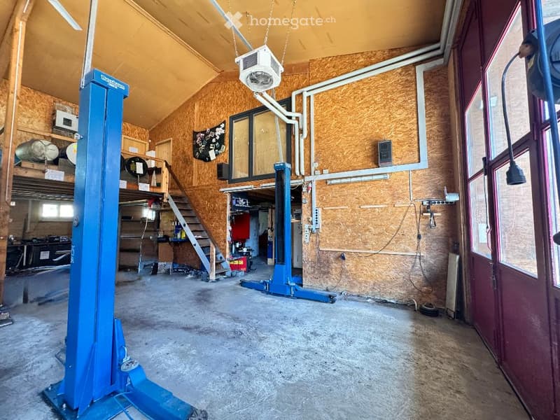 {"visible_features": ["Garage"], "type": "Garage", "objects": [], "description": "Garage with wooden walls, concrete floor, blue lift, and various tools and equipment stored on shelves and in the background.", "localized_descriptions": {"EN": "Garage with