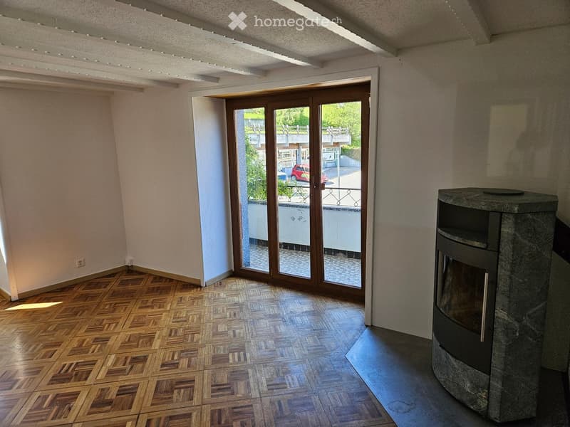 Furnished Room. Bright room with wooden parquet flooring, large sliding glass door leading to a balcony, and a stone fireplace.