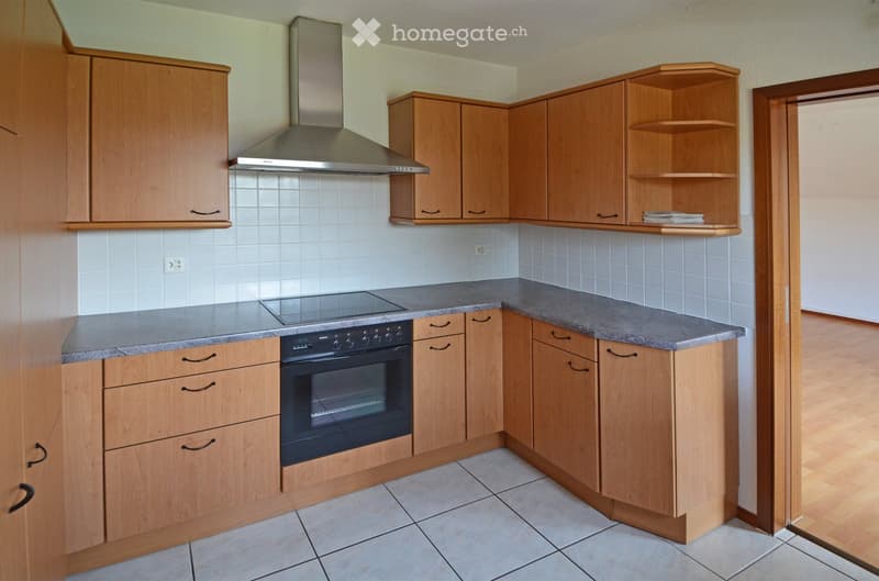 Modern kitchen with wooden cabinetry, white tiles, granite countertops, integrated oven, stove, dishwasher, and sink