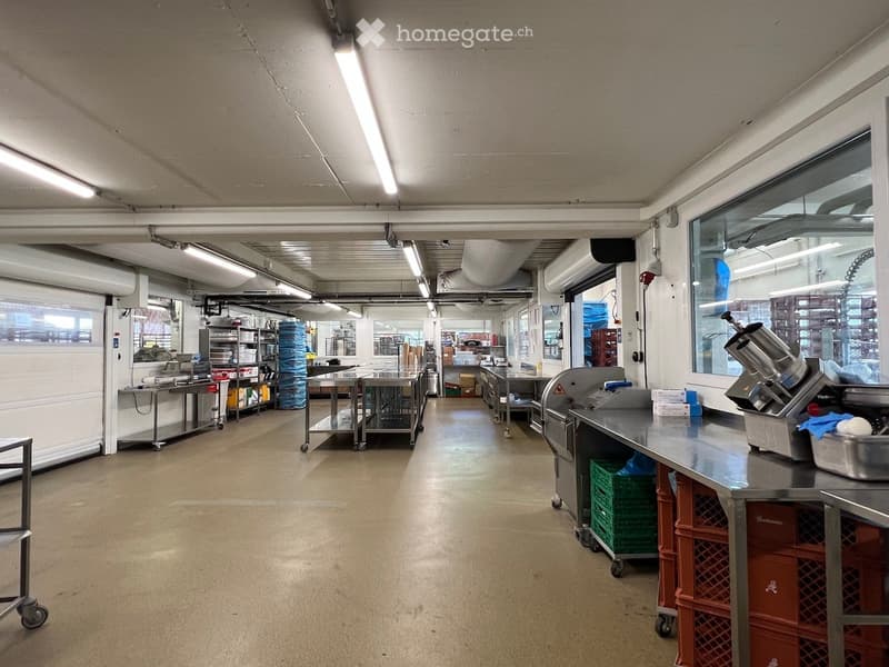 empty room with stainless steel counters, carts, machines, and storage boxes