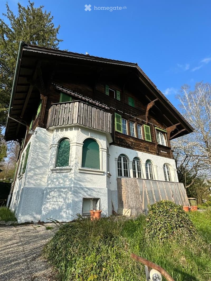 2 story house, wooden exterior, white walls, green shutters, balcony, large windows, driveway