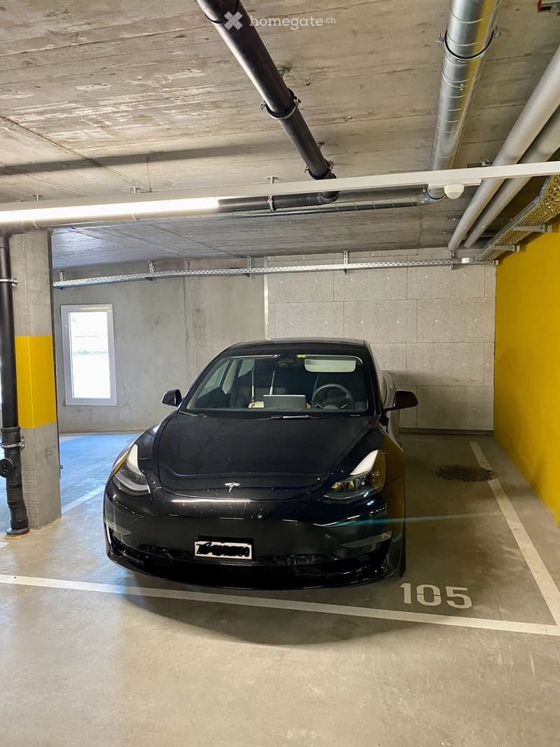 {"visible_features": ["Garage"], "type": "Garage", "objects": [], "description": "Underground parking space with a single car parked in bay number 105, concrete walls and ceiling, fluorescent lighting, and a small window on the left side.", "localized_des