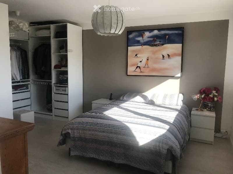 Bright bedroom with a large bed, nightstands, wardrobe, and a painting on the wall.