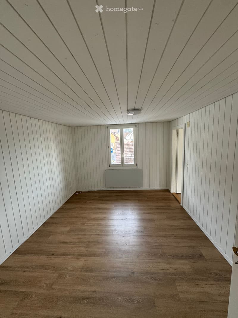 empty room with white walls, wooden floor, window with white frame