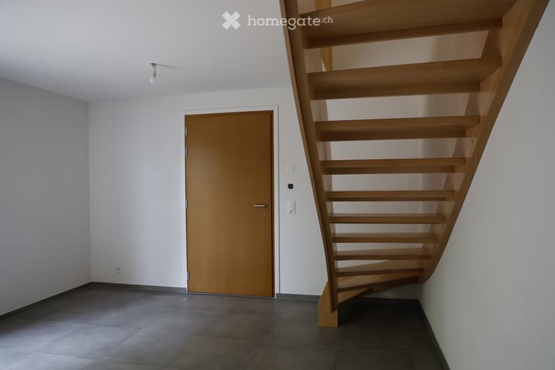 Empty room, wooden door, wooden staircase, tiled floor, white walls, light fixture