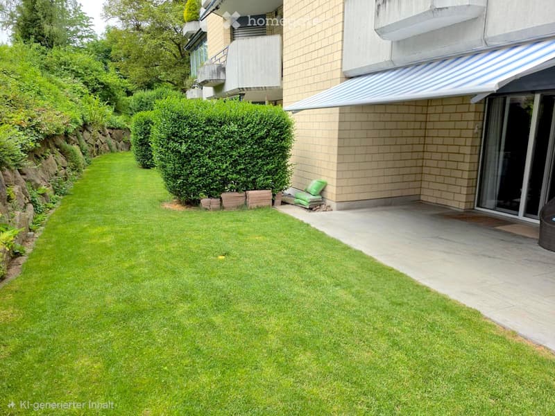 Well-maintained lawn with trimmed hedges, a stone retaining wall, and a modern building with a covered entrance and balcony.