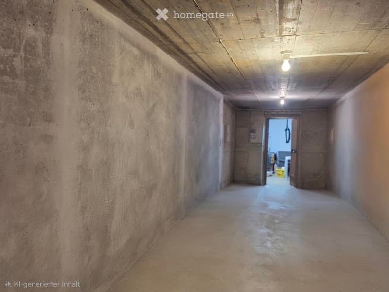 Empty concrete corridor with exposed ceiling beams, fluorescent lighting, and two open doors at the end.