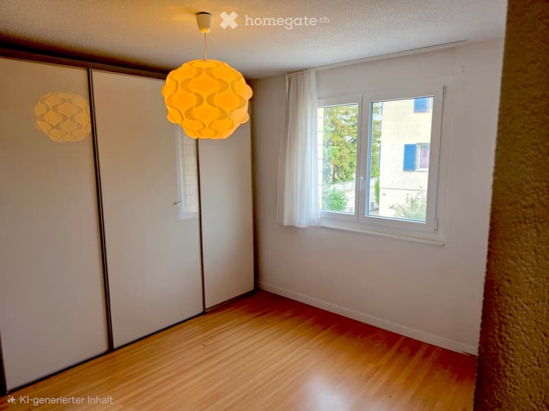 Empty room with wooden flooring, white walls, large windows with white curtains, and modern pendant lights.