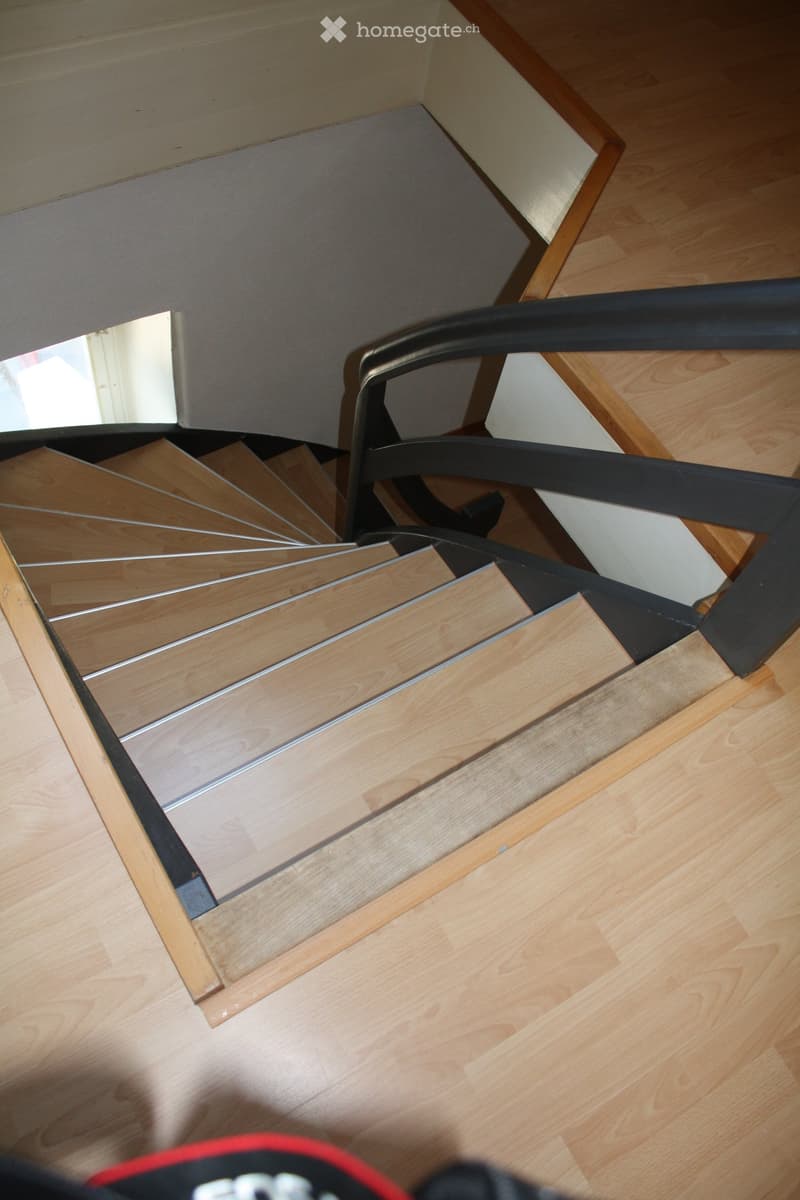 interior stairs with wooden steps and black railing