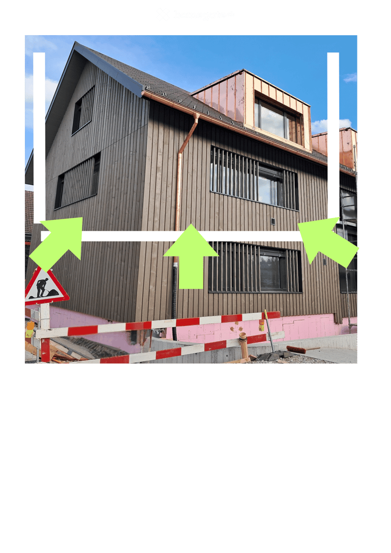 Modern two-story building with wooden facade, multiple windows, and a raised ground floor area with construction barriers and tools.