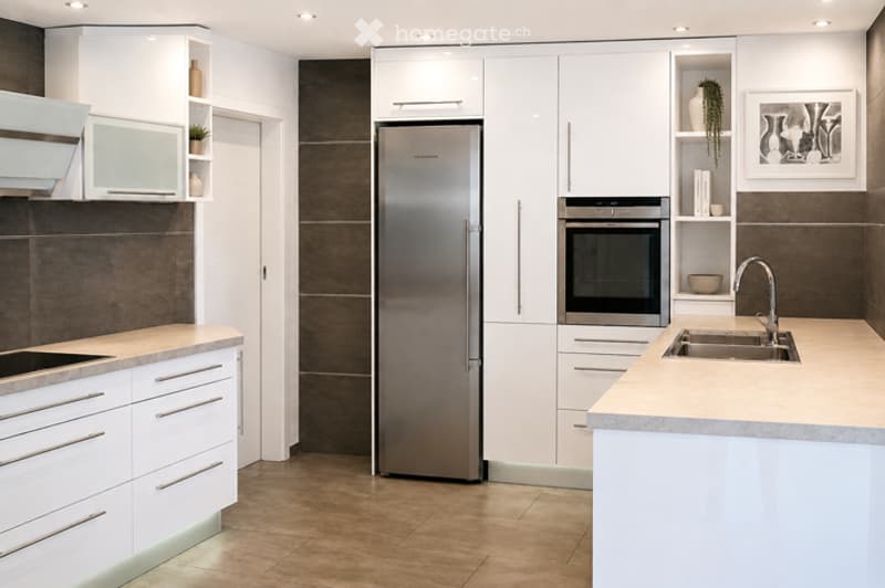 Modern kitchen with white cabinets, stainless steel appliances, and a central island with a sink and faucet.