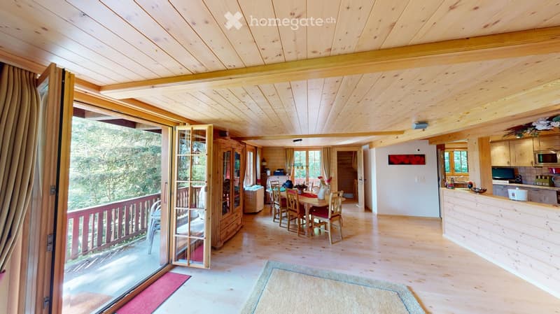 Bright, wooden-floored living space with a dining area, kitchen, and balcony access. Features a dining table with chairs, a wooden cabinet, and a modern kitchen with appliances.