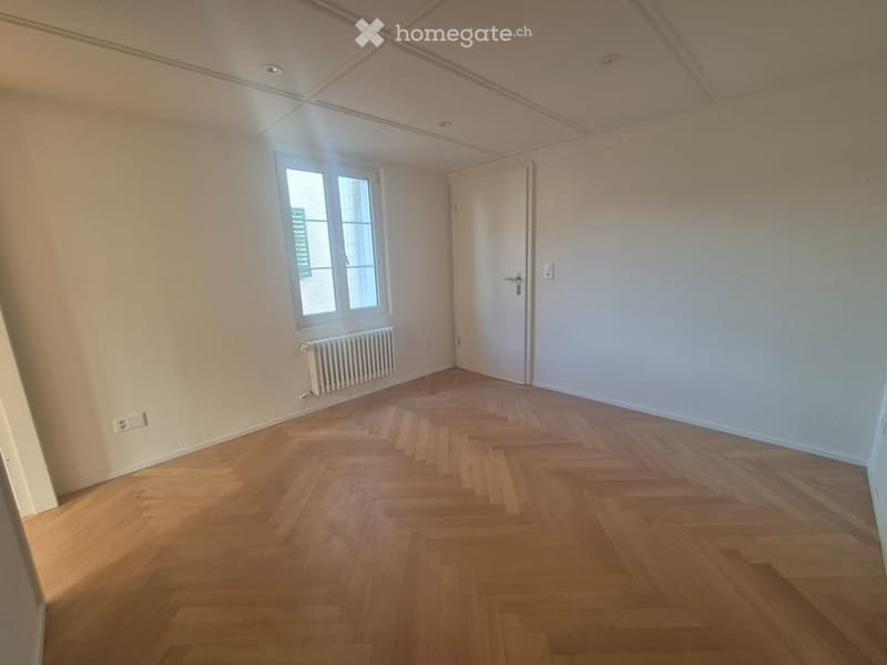 empty room, wooden parquet floor, white walls, window, radiator, door