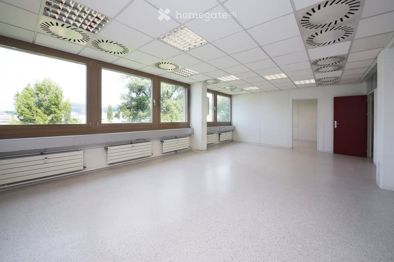 Empty room with white walls, large windows, and a polished concrete floor. No furniture or equipment is present.