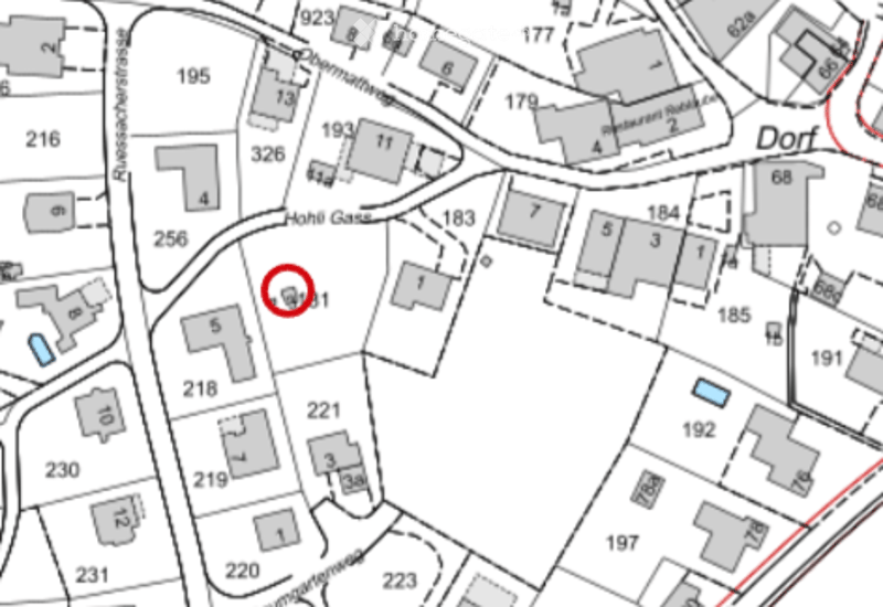 Floor plan of a residential area showing multiple buildings and numbered plots, with a highlighted plot marked with a red circle.
