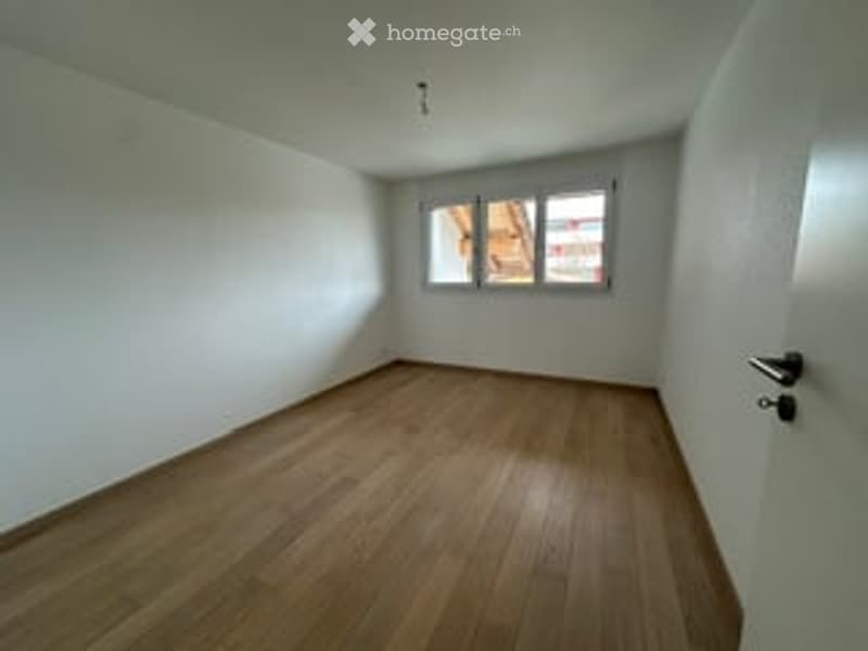 Completely empty room with bare white walls and wooden floor. No furniture or equipment.