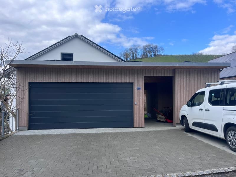 Modern two-story house with a garage, white van parked in front, and a well-maintained driveway.