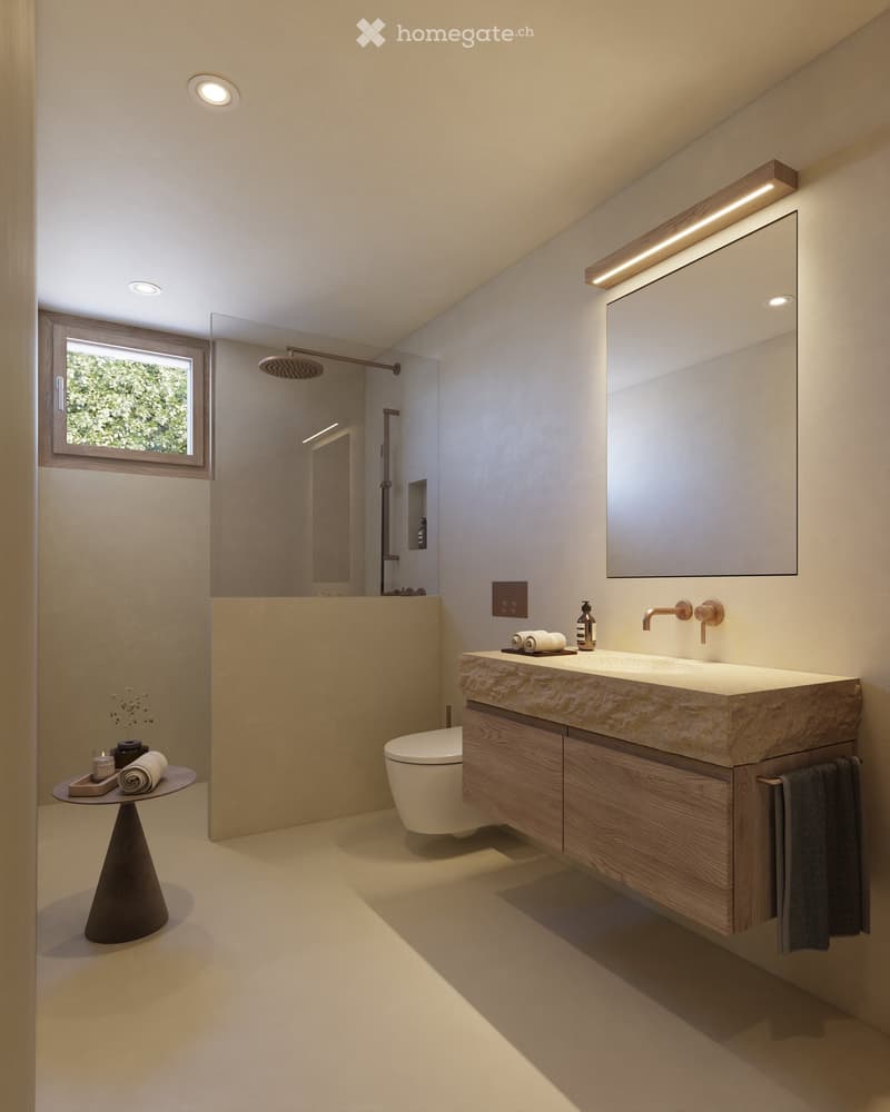 Modern bathroom with a large sink, mirror, toilet, and a small table with towels and a bottle. The space features recessed lighting and a large window with a view of greenery.