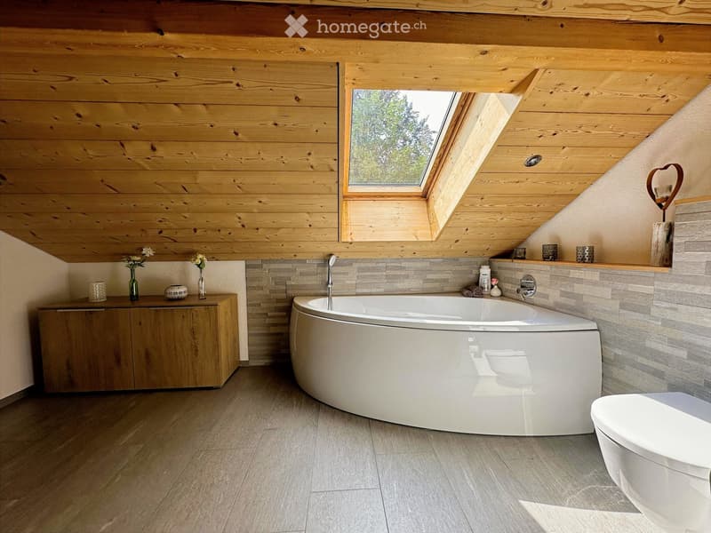 Modern bathroom with wooden walls and ceiling, large bathtub, toilet, wooden cabinet, and decorative vases.
