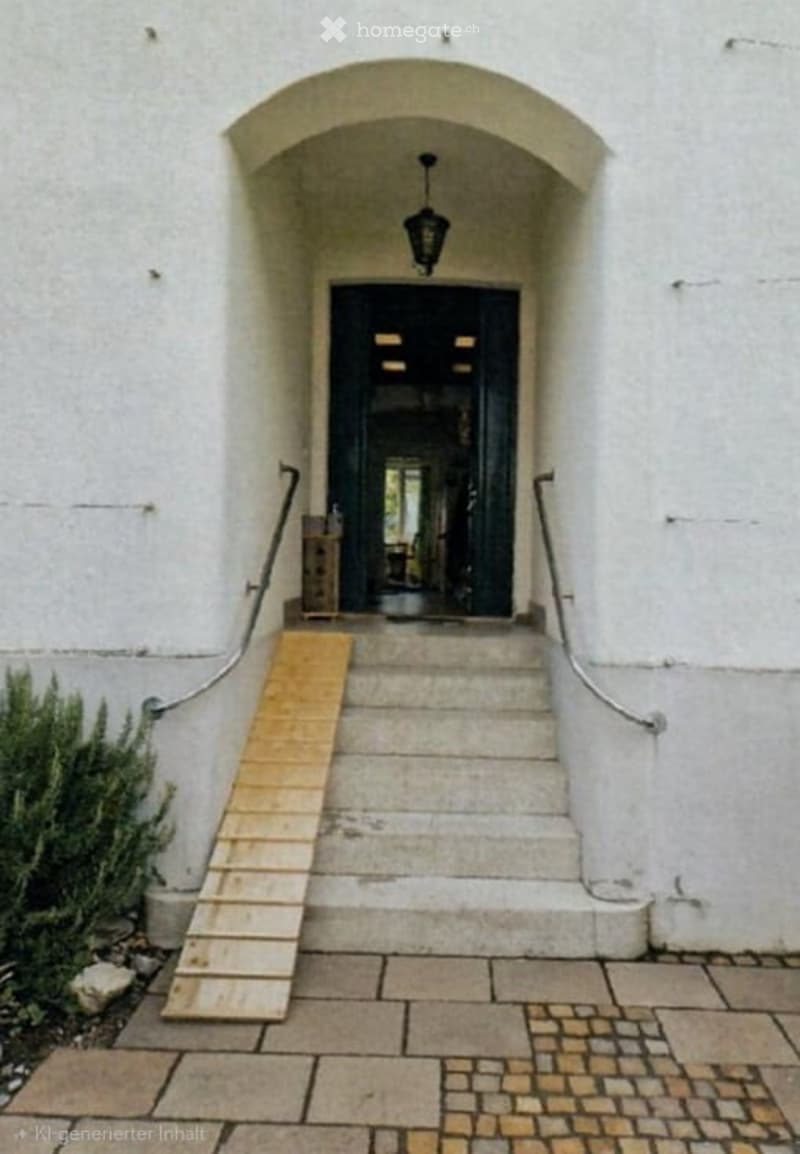 Entrance to a building with a raised ground floor, featuring a wooden ramp, stone steps, and a black door under an arched white stone entranceway.