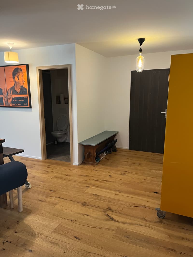 The room features wooden flooring, a bench, a stool, a screen, and a partially visible toilet in the background.
