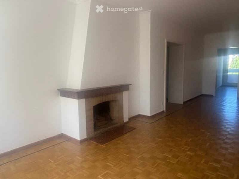 Empty room with wooden flooring and a fireplace against one wall. The space is unfurnished, with no visible furniture or equipment.