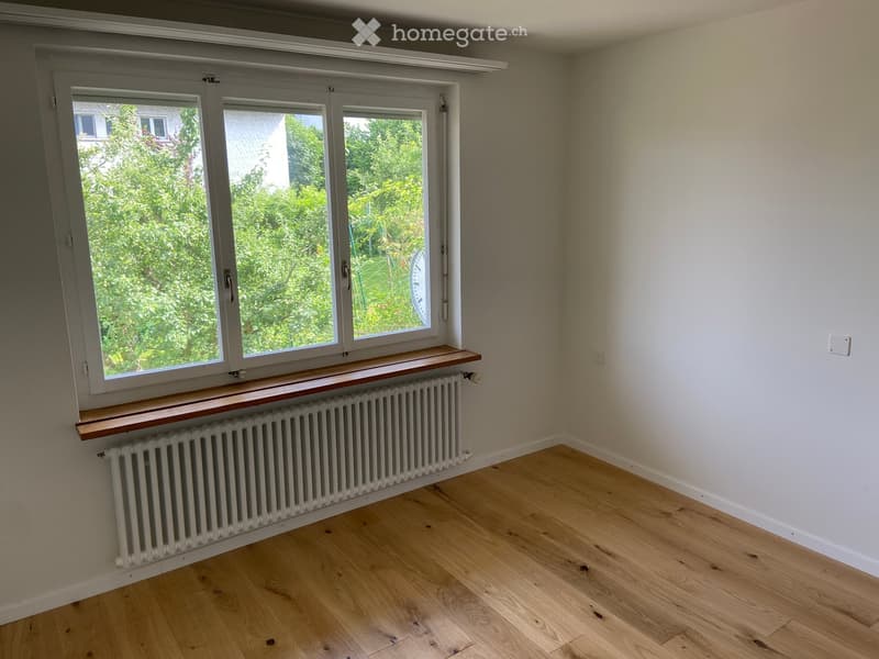 empty room, white walls, wooden floor, large window, white radiator